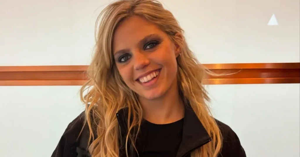 Blonde hair, casual black outfit.